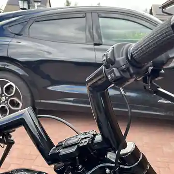 Close-up of gloss black custom Steel Guru handlebars on a Harley-Davidson